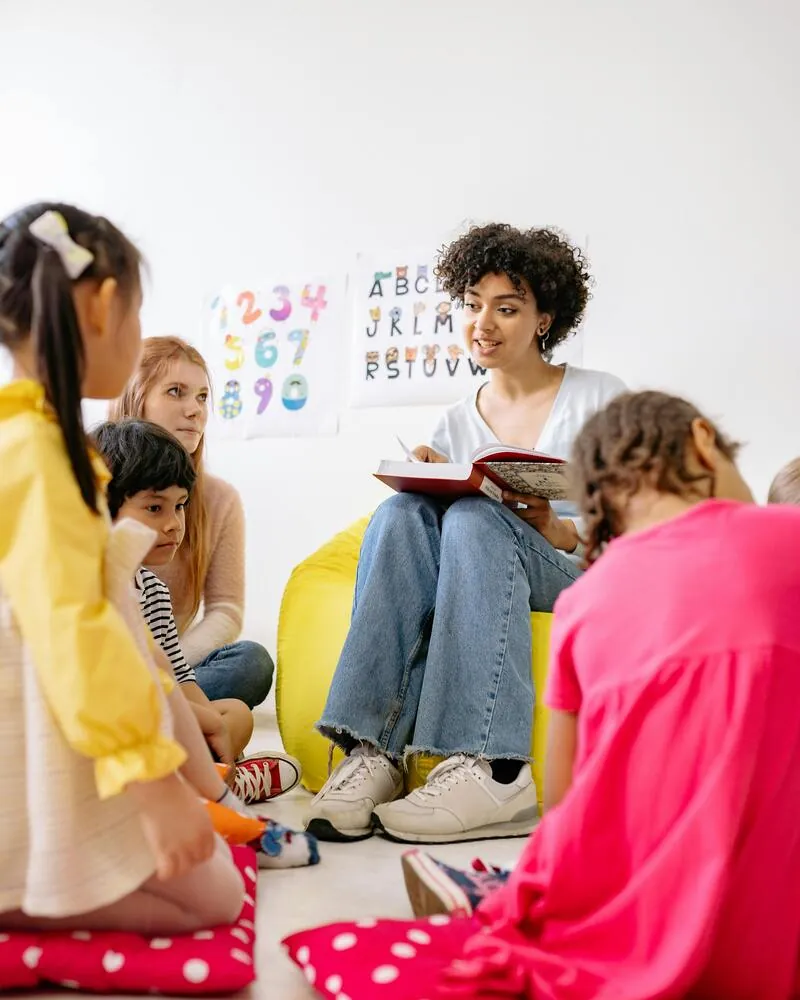 Maestra leyendo a niños preescolares en aula del programa Técnico Laboral Asistente Primera Infancia Córdoba