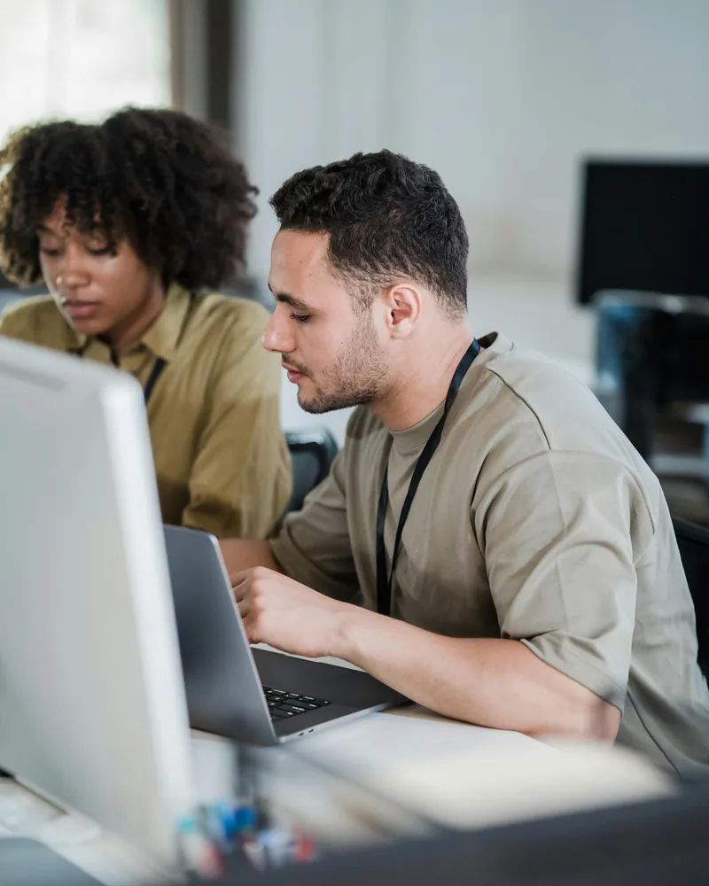 Compañeros de oficina colaborando en computador, formación Técnico Laboral en Asistente Administrativo Córdoba