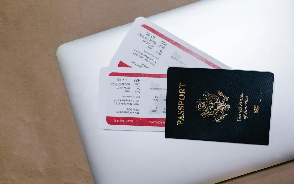Pasaporte y boarding passes sobre laptop, gestión de reservas y boletos en agencias de viajes Córdoba