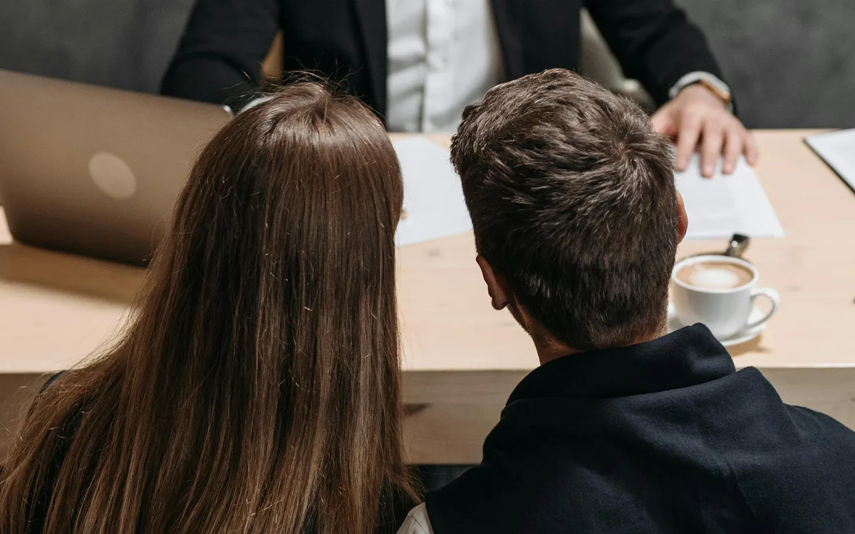 Profesional asesorando pareja en oficina, etapa productiva Técnico Laboral en Agencia de Viajes Córdoba