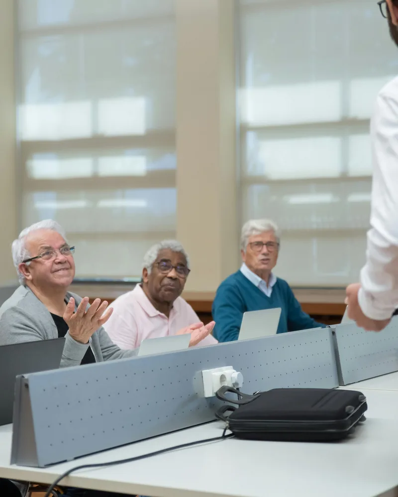 Adultos en clase de computación con instructor, formación Técnico Laboral en Agencia de Viajes y Turismo Córdoba
