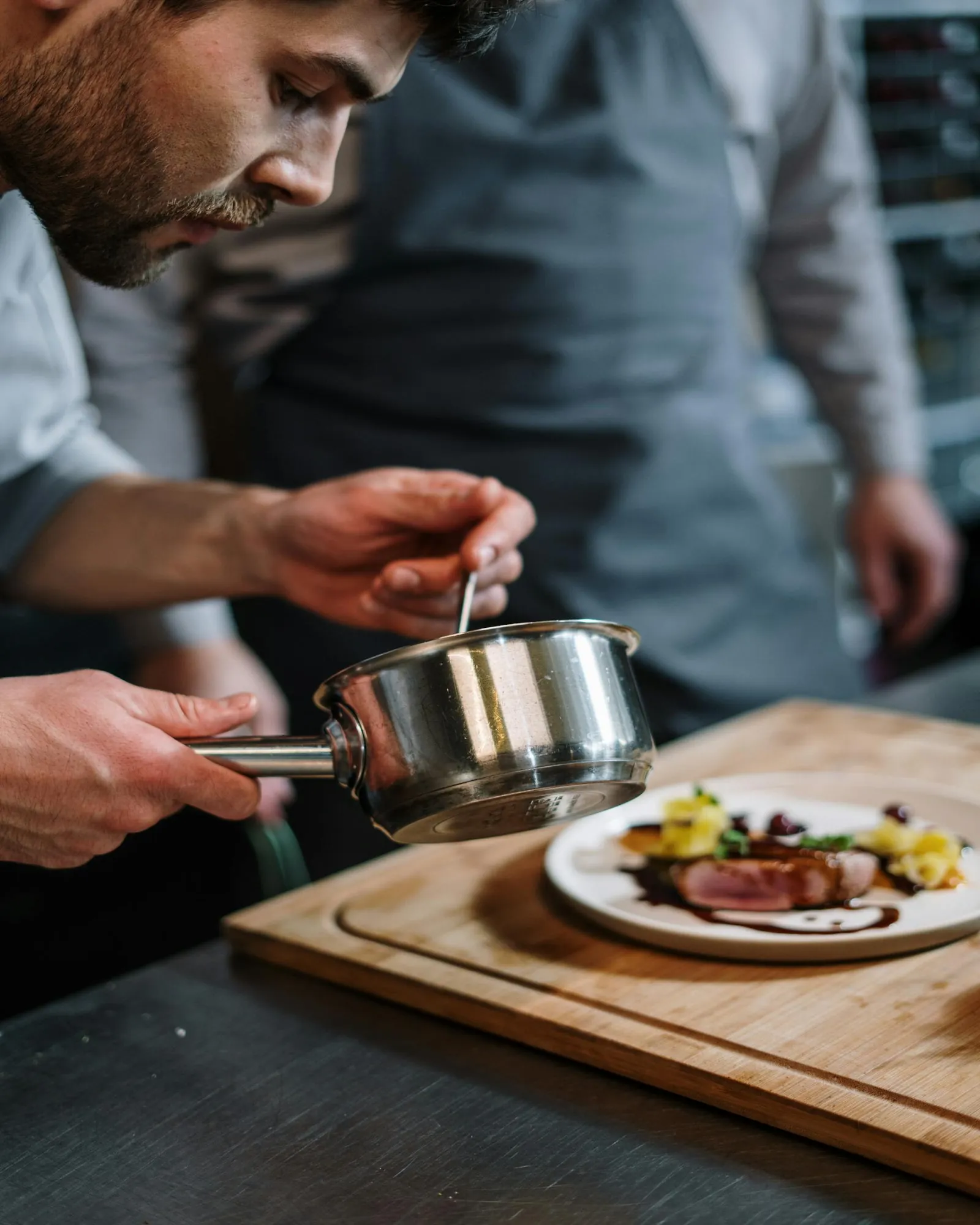 Chef profesional emplata plato gourmet con salsa, programa Técnico Laboral en Cocina Córdoba