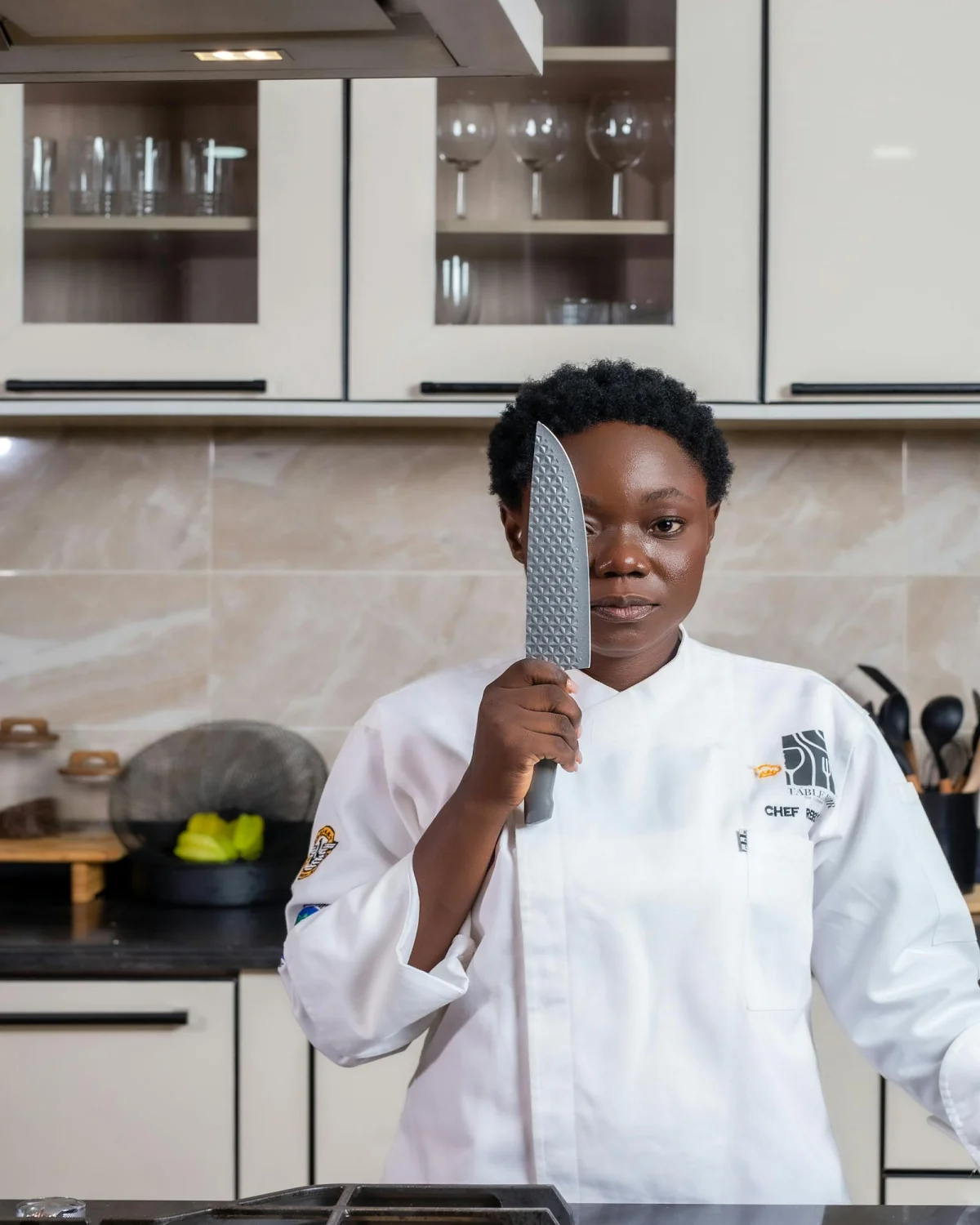 Chef confiado con cuchillo en cocina moderna, fundamentos del programa Técnico Laboral en Cocina