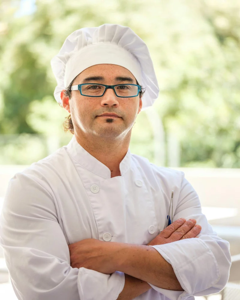 Chef profesional con uniforme y toque blanche, sello profesional del programa Técnico Laboral en Cocina