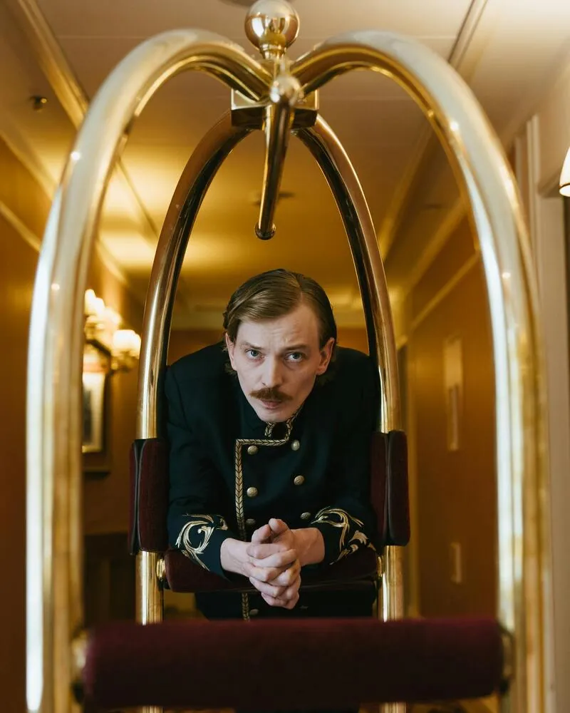 Bellboy uniformado en pasillo de hotel elegante, profesionalismo del sector hotelero