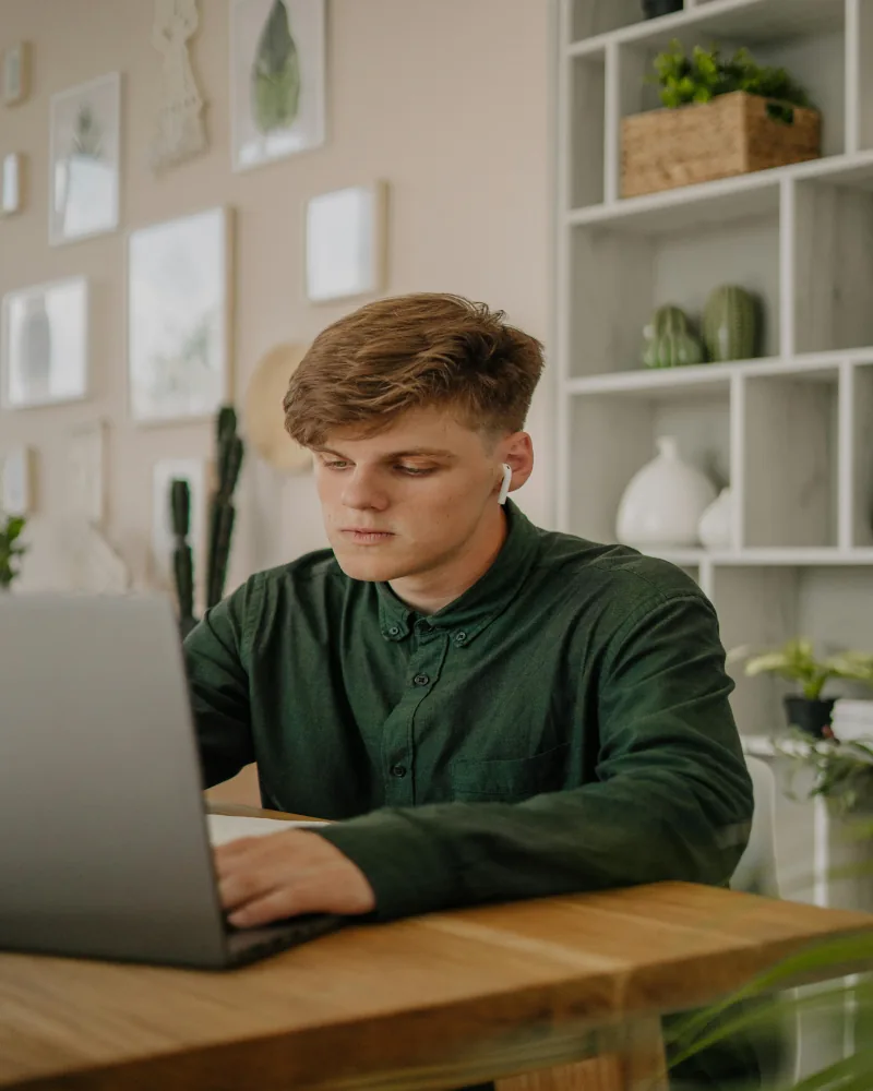 Joven con laptop en casa, inscripción digital al programa Técnico Laboral Los Libertadores