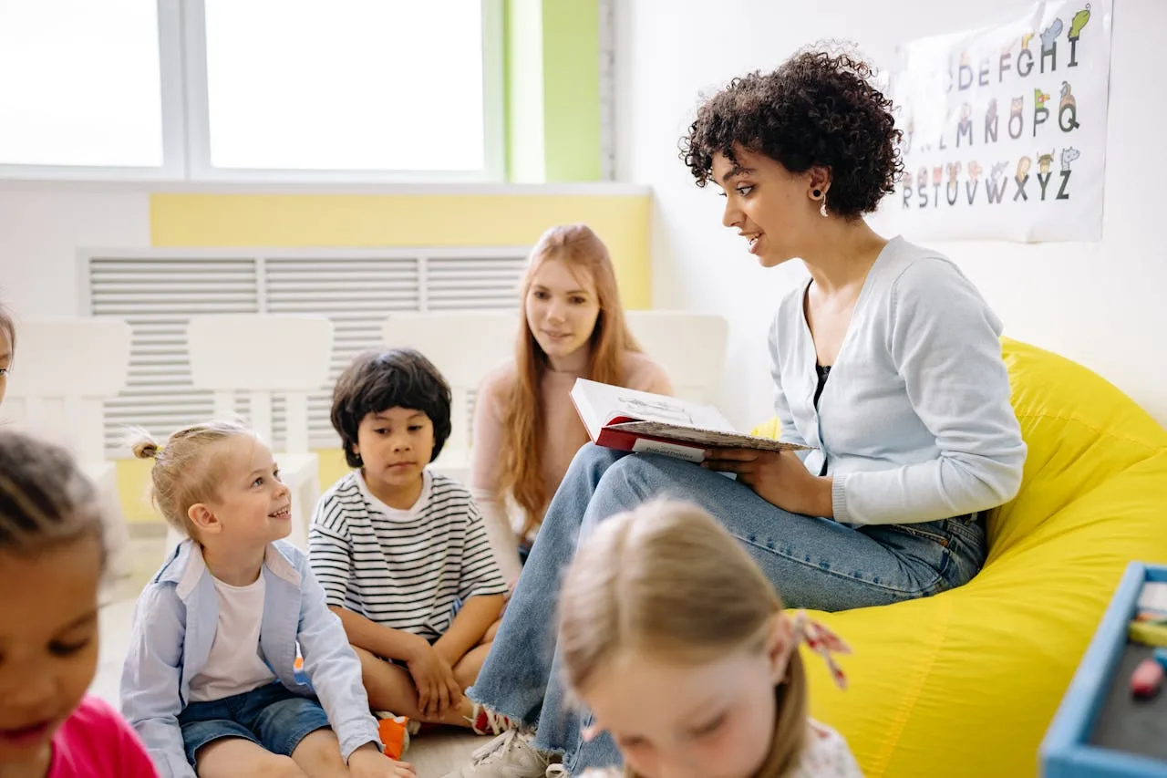 Auxiliar leyendo a niños en educación inicial