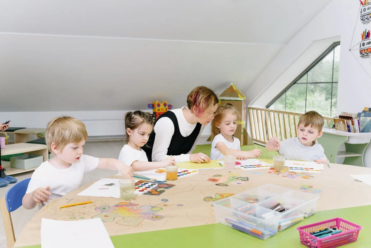 Niños en actividad artística con auxiliar pedagógica