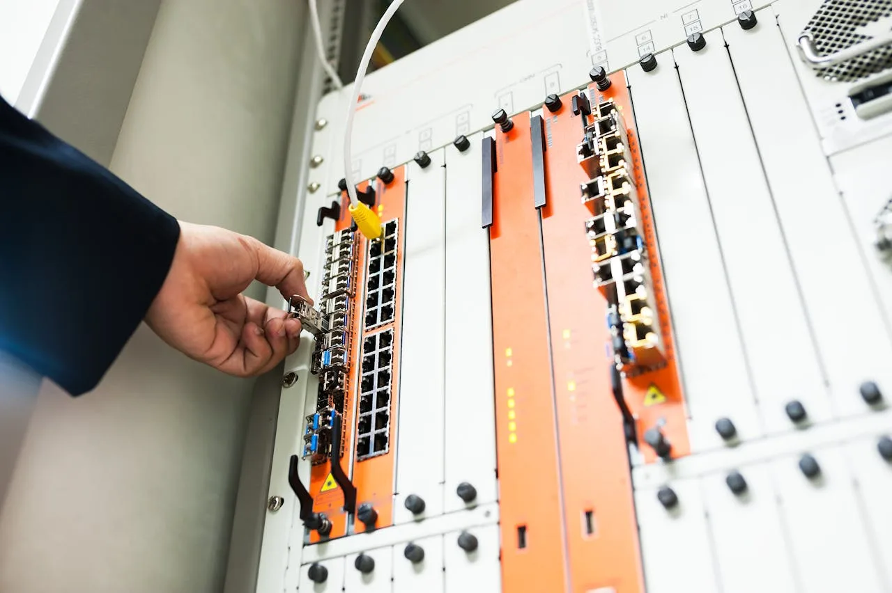 Técnico configurando switch y router en rack de telecomunicaciones